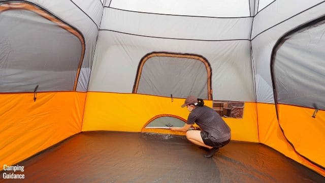 This is a picture of me inside the Core 10-Person Straight Wall Cabin Tent measuring the dimensions of the ground vent (32 by 9 inches).