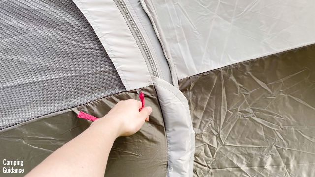 This is a picture of me reaching for the handle of the hinged D-door of the Coleman WeatherMaster 10-Person Tent.