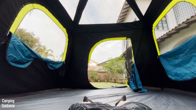 This is a picture of me lying down in my Coleman 10-Person Instant Cabin Tent with all the windows, doors and ceiling mesh opened for plenty of ventilation.