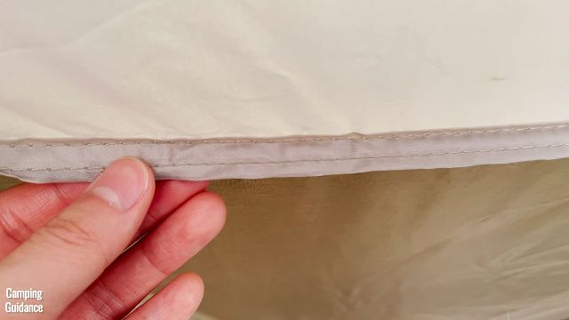 This is the seam connecting the lighter brown fabric to the darker brown fabric of the tent body of the WeatherMaster 10-Person Tent.