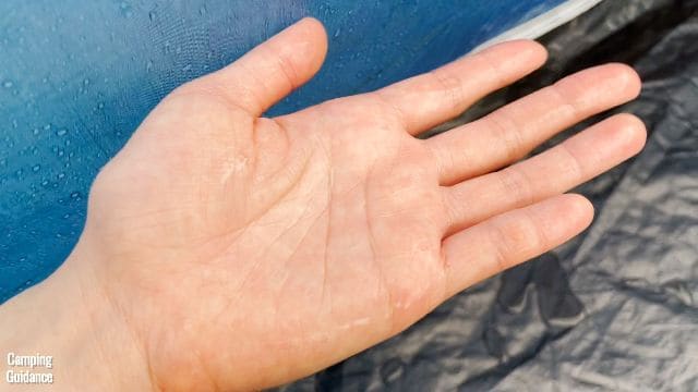 This is a picture of my hand after I touched the blue fabric at the bottom of the Ozark Trail 10-Person Cabin Tent. My hand is pretty damp.