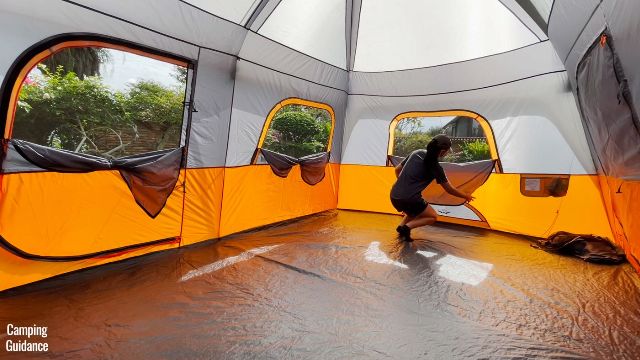 This is a picture of me unzipping all the windows of the Core 10-Person Straight Wall Cabin Tent. From the left to right, you can see the mesh paneling from one of the doors, and also 2 identical windows.