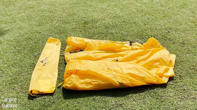 This is a picture of me folding the rainfly (right) of the Teton Sports 2-Peson Vista Quick Tent to make it small enough to fit back into the carry bag (left).