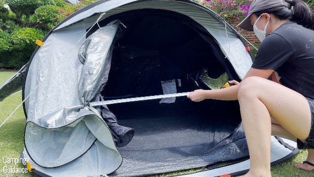 This is a picture of me using a tape measure to measure the dimensions of the door of the Quechua 2 Seconds Fresh and Black Tent.