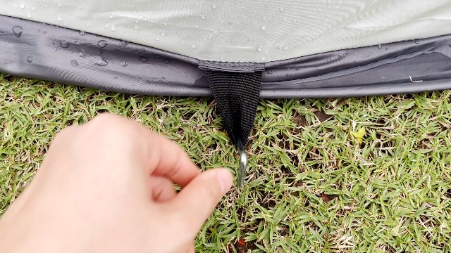 This is what the black stake loop of the Coleman 4-Person Pop Up Tent looks like. I’ve already driven a stake through it.