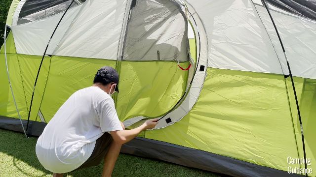 This is a picture of my brother curving one of the hinged D-door fiberglass poles into place, to secure the hinged door of the Coleman Montana 8-Person Tent.