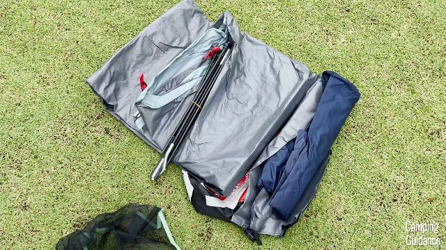 This is what the Coleman Skydome 4-Person Tent looked like out of the box. In this picture you can see the tent body with the attached poles (gray and black), the rainfly (blue), and the gear loft at the bottom (black).