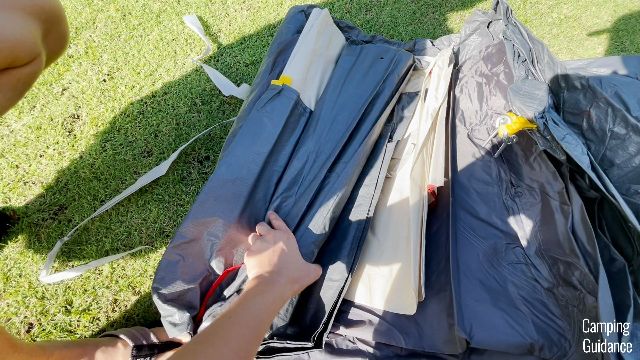 This is a picture of me unboxing the Coleman Red Canyon 8-Person Tent. I'm holding onto the fiberglass poles, which come in a separate carry bag.