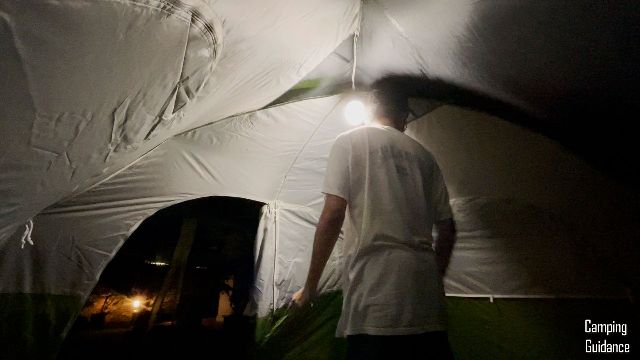 This is a picture of my brother hanging up a lantern in the Coleman Evanston 6-Person Tent at night.