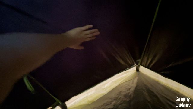 This is a picture of me touching the blackout fabric of the Coleman Sundome Dark Room Tent.