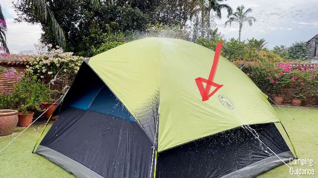 The red arrow in this picture is pointing to the mesh wall vent of the Coleman Sundome Dark Room Tent. You can't see it from here because it's fully covered by the rainfly.