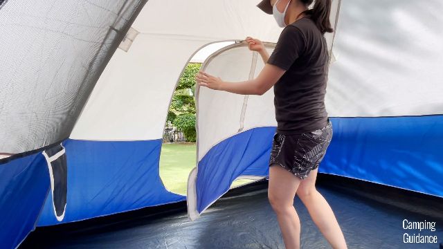 This is a picture of me zipping the back door of the Coleman Elite Sundome Tent closed.