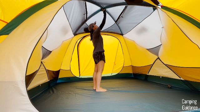 This is a picture of me standing under the peak height of the REI Base Camp 6.