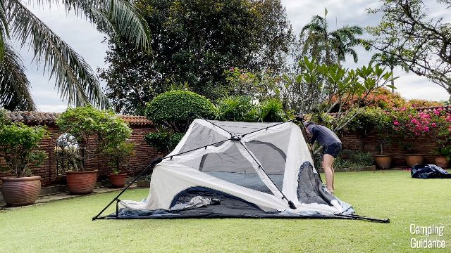The author extending the second pole of the Caddis Rapid 6 instant tent.