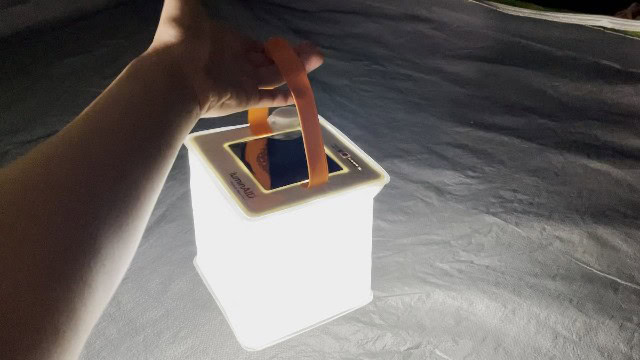 The author holding the handle of the LuminAID PackLite Max.